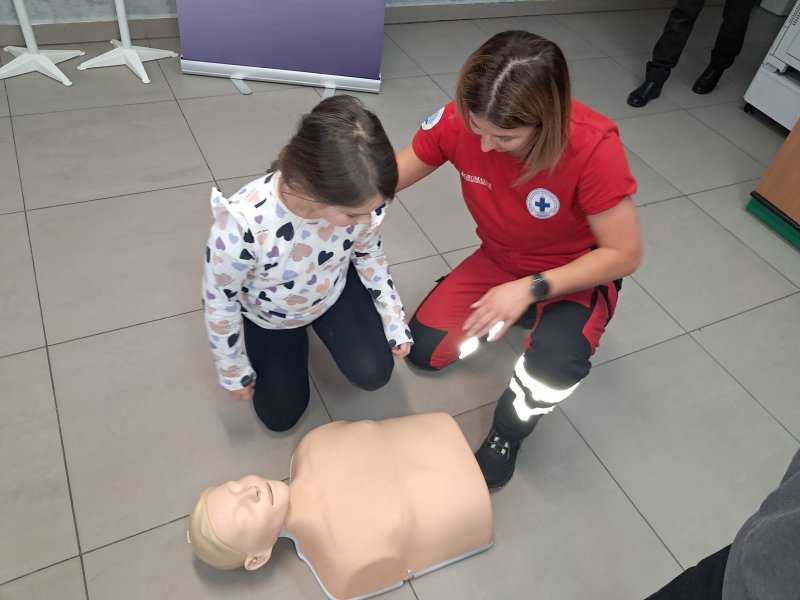 Zdjęcie przedstawia uczestniczkę zajęć w trakcie nauki udzielania pierwszej pomocy z wykorzystaniem fantoma.  