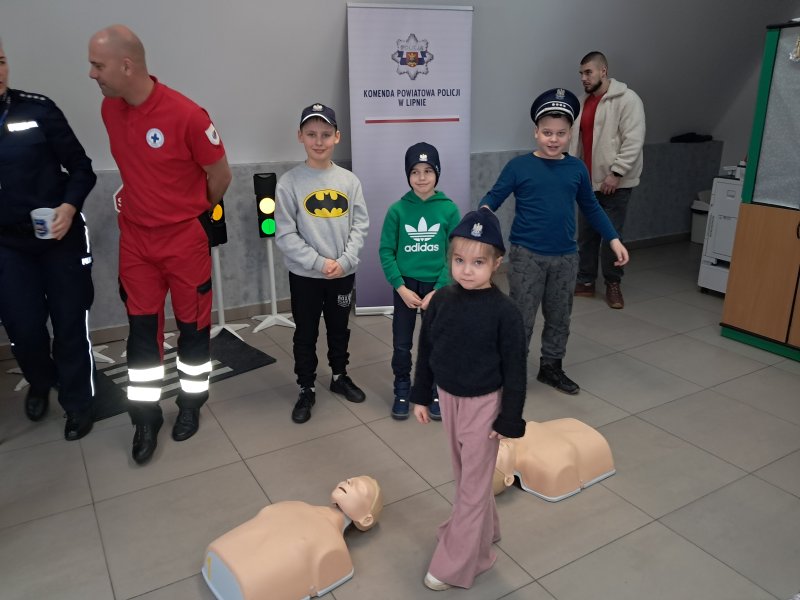 Zdjęcie przedstawia dzieci ubrane w policyjne czapki  