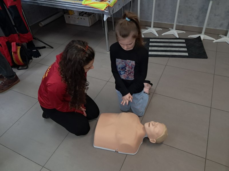 Zdjęcie przedstawia uczestnika zajęć w trakcie nauki udzielania pierwszej pomocy z wykorzystaniem fantoma.  