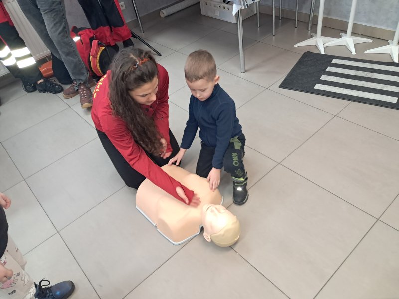 Zdjęcie przedstawia uczestnika zajęć w trakcie nauki udzielania pierwszej pomocy z wykorzystaniem fantoma.  