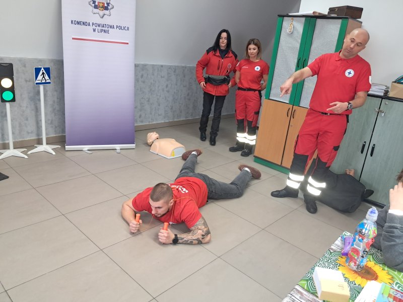 Zdjęcie przedstawia trójkę ratowników prezentujących przyrządy potrzebne do wydostania się z wody na lód oraz bezpiecznego przesuwania się po płaszczyźnie lodu.  