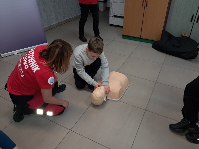 Zdjęcie przedstawia uczestnika zajęć w trakcie nauki udzielania pierwszej pomocy z wykorzystaniem fantoma.  