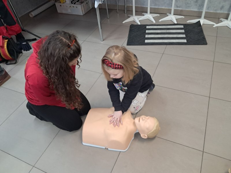 Zdjęcie przedstawia uczestnika zajęć w trakcie nauki udzielania pierwszej pomocy z wykorzystaniem fantoma.  