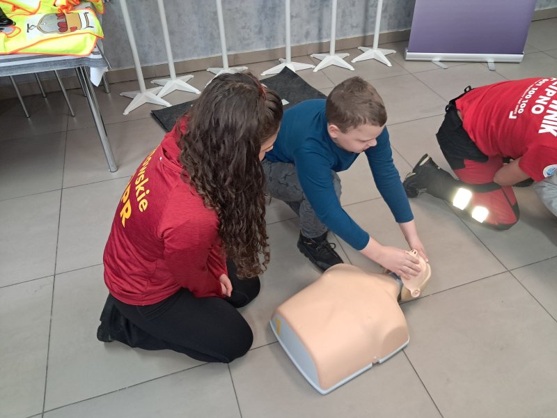 Zdjęcie przedstawia uczestnika zajęć w trakcie nauki udzielania pierwszej pomocy z wykorzystaniem fantoma.  