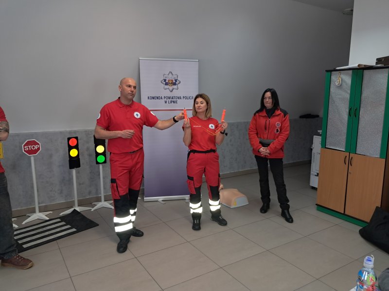 Zdjęcie przedstawia trójkę ratowników prezentujących przyrządy potrzebne do wydostania się z wody na lód oraz bezpiecznego przesuwania się po płaszczyźnie lodu.  