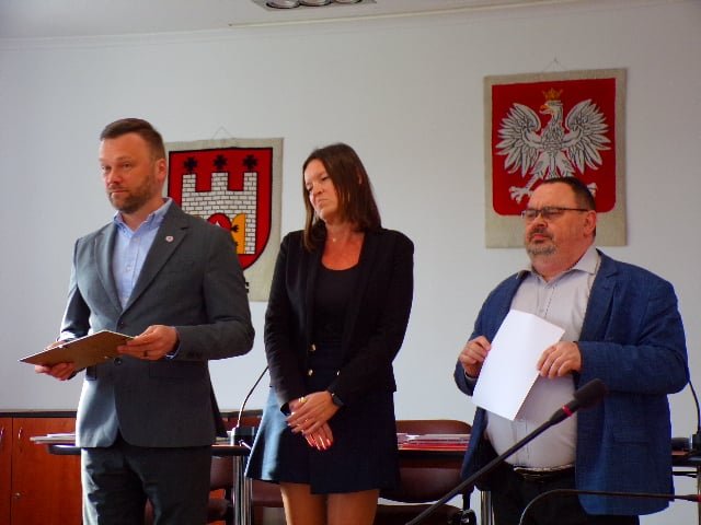Fotografia przedstawia organizatorów konkursu przemawiających w sali konferencyjnej urzędu do uczestników.  
