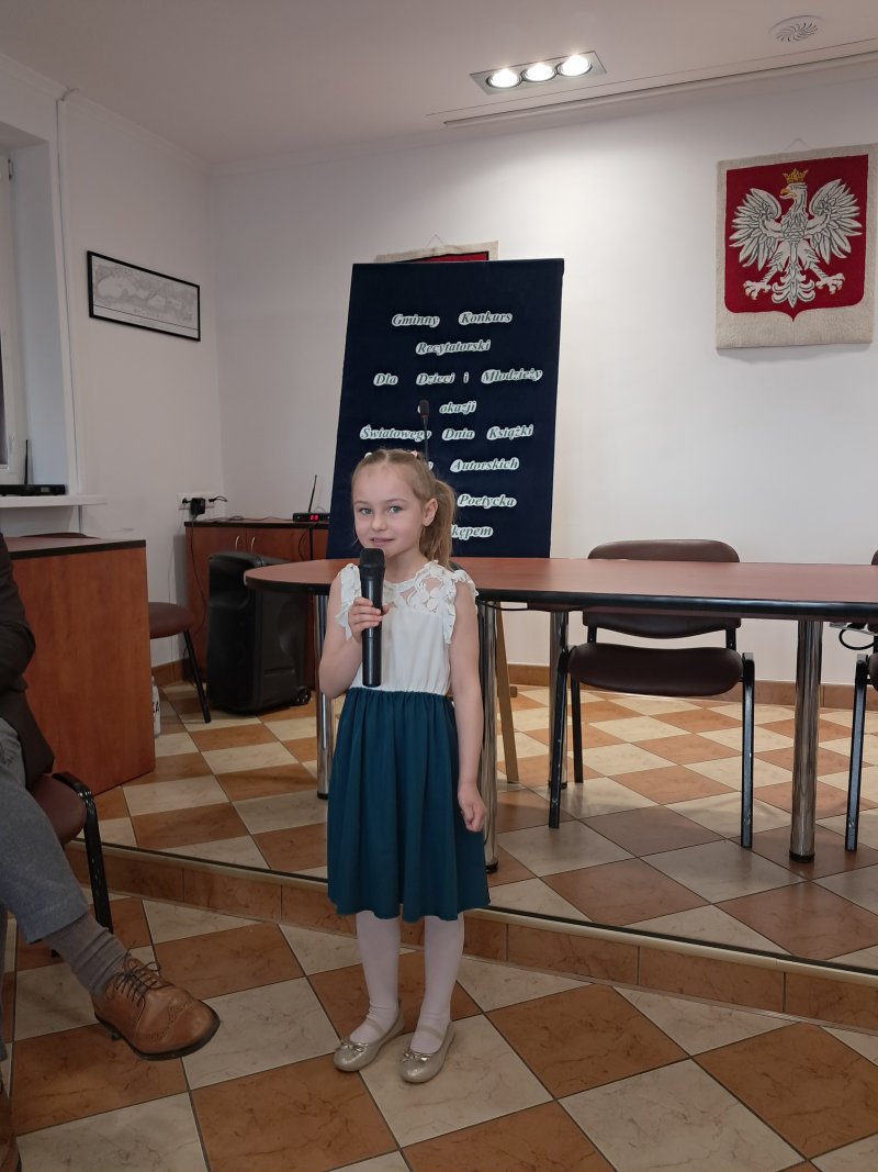 Zdjęcie przedstawia uczestniczkę konkursu w trakcie recytacji.  