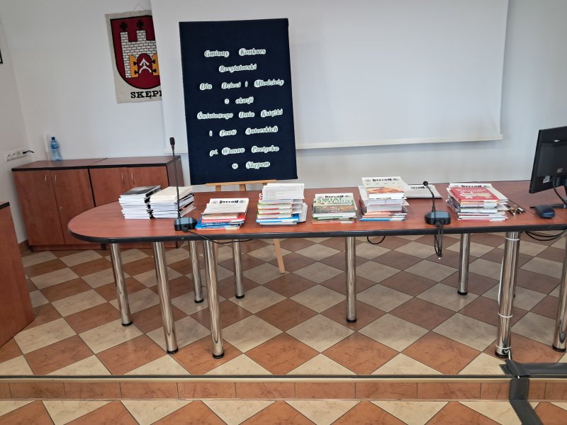 Zdjęcie przedstawia nagrody i dyplomy dla laureatów konkursu leżące na stoliku.  