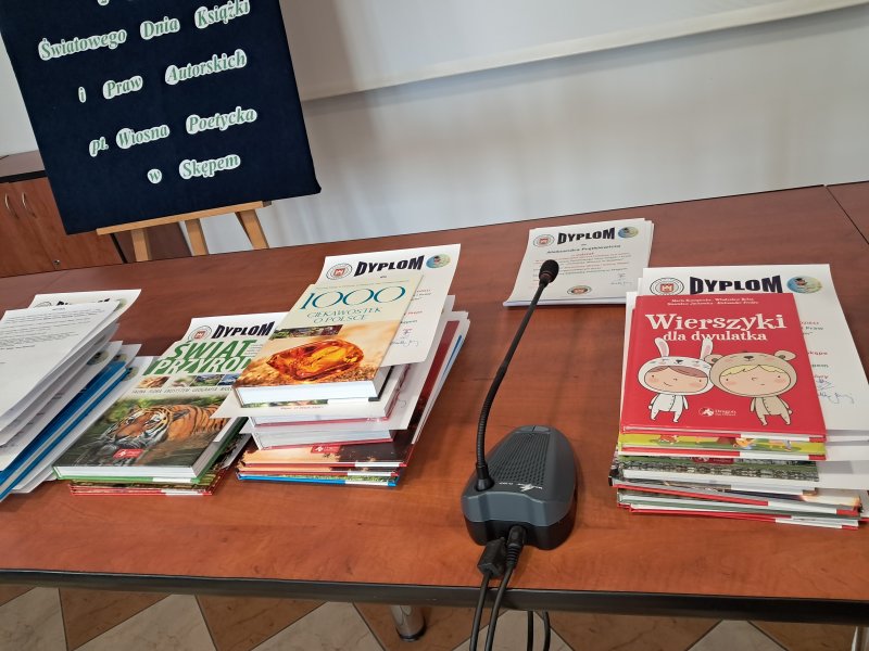 Zdjęcie przedstawia nagrody i dyplomy dla laureatów konkursu leżące na stoliku.  