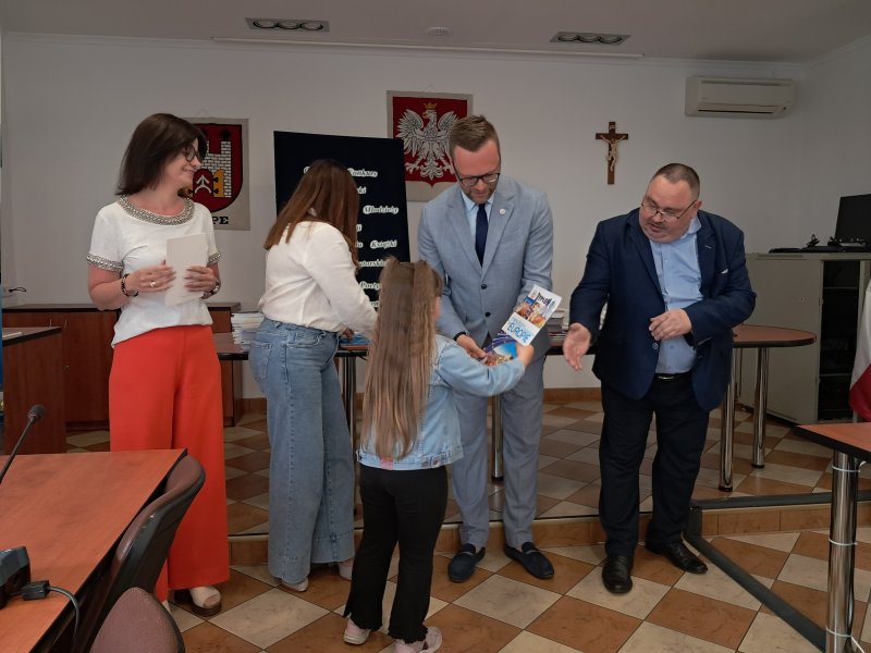 Zdjęcie przedstawia Burmistrza Skępego i członków Jury konkursu recytatorskiego wręczających nagrodę uczestnikowi konkursu.  