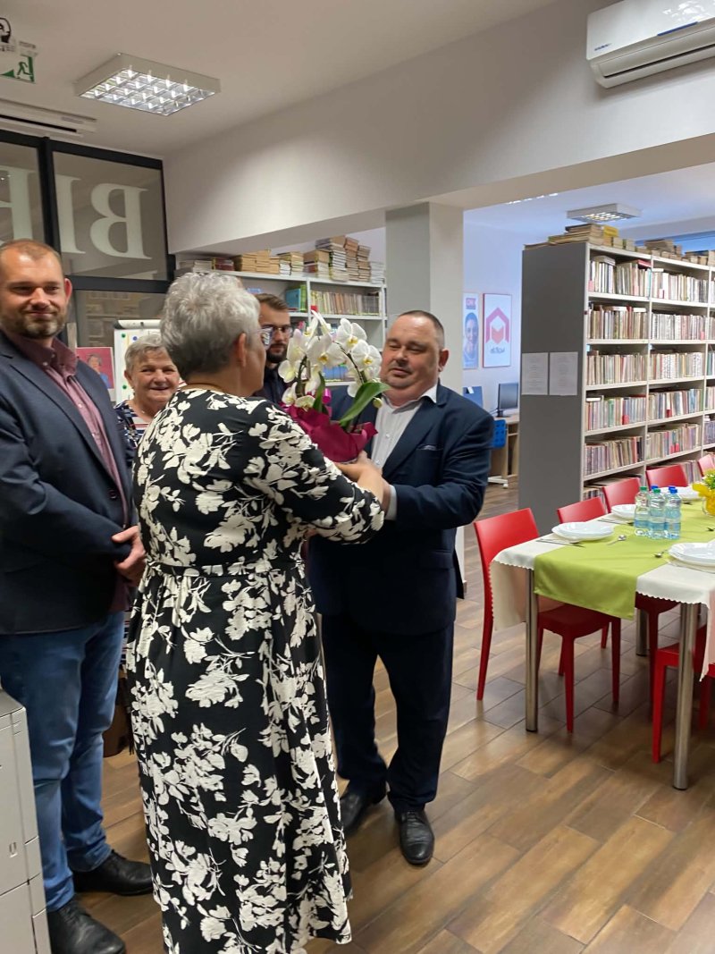 Na fotografii widać moment wręczenia doniczki z kwiatami przez dyrektora biblioteki w Skępem dyrektorowi Biblioteki w Wielgiem  