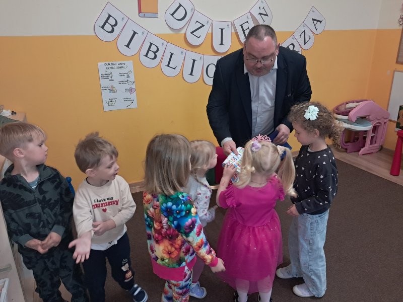Na zdjęciu dzieci przedszkolne z „Klubu Malucha” wręczają dyrektorowi biblioteki podziękowanie za lekcję biblioteczną  