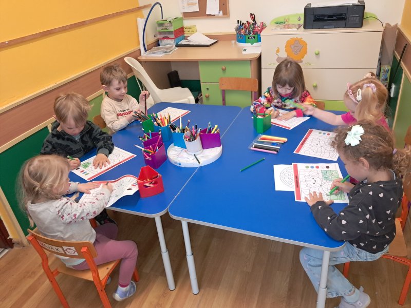 Zdjęcie przedstawia dzieci siedzące przy stoliku w trakcie zajęć plastycznych w „Klubie Malucha” w Skępem  