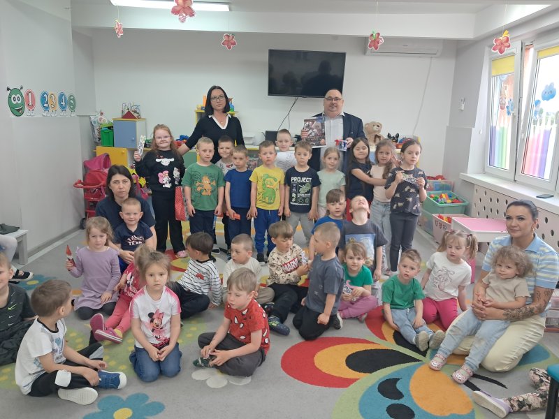 Fotografia przedstawia wspólne zdjęcie przedszkolaków i dyrektora skępskiej biblioteki w Publicznym Przedszkolu w Skępem  