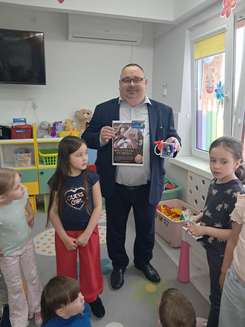 Na zdjęciu widać przedszkolaków z Publicznego Przedszkola w Skępem wręczających dyrektorowi skępskiej biblioteki podziękowanie za przeprowadzoną lekcję biblioteczna  