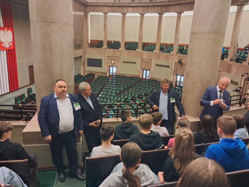 Fotografia przedstawia uczestników wycieczki do Sejmu siedzących na galerii sejmowej  