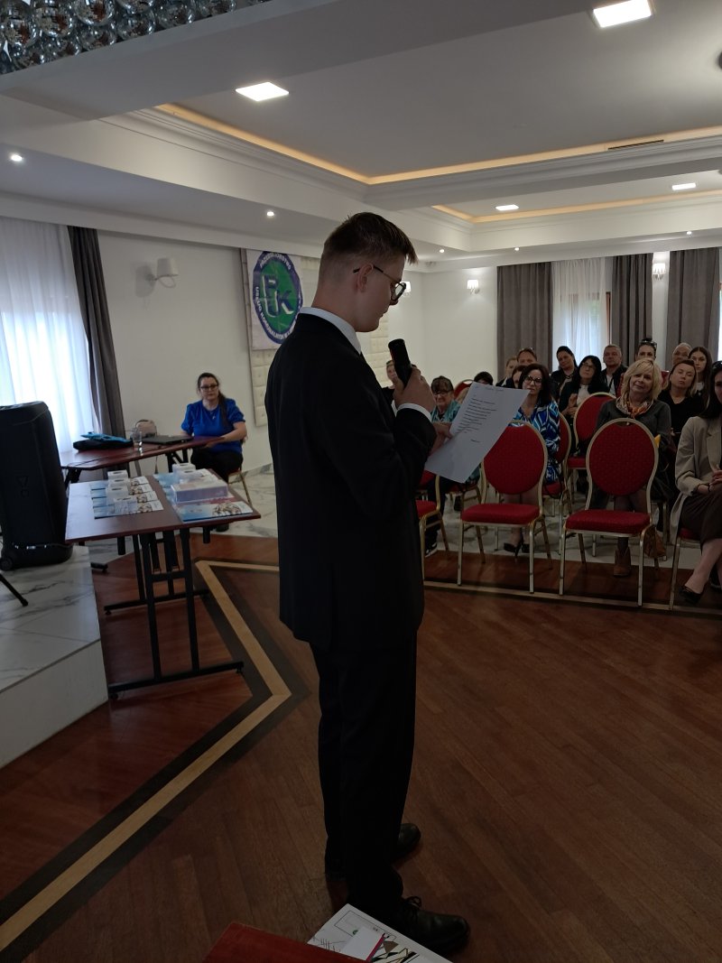 Zdjęcie przedstawia laureata konkursu czytającego nagrodzony wiersz  