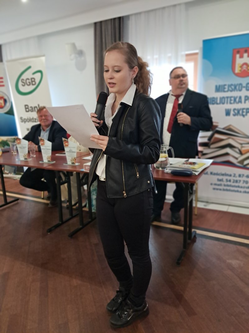 Zdjęcie przedstawia laureatkę konkursu czytającą nagrodzony wiersz  