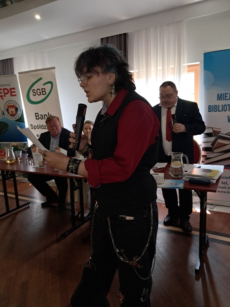 Zdjęcie przedstawia laureata konkursu czytającego nagrodzony wiersz  