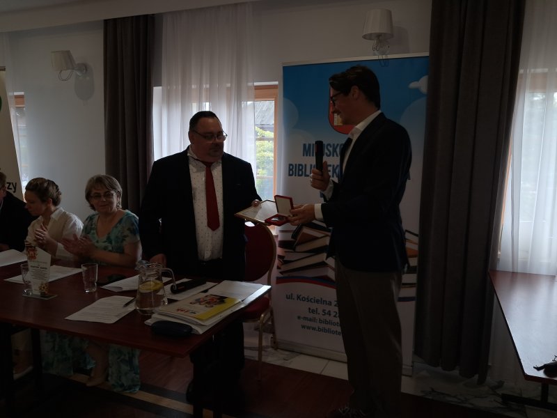 Zdjęcie przedstawia moment wręczenia dyrektorowi biblioteki podziękowania od posła Arkadiusz Myrchy  