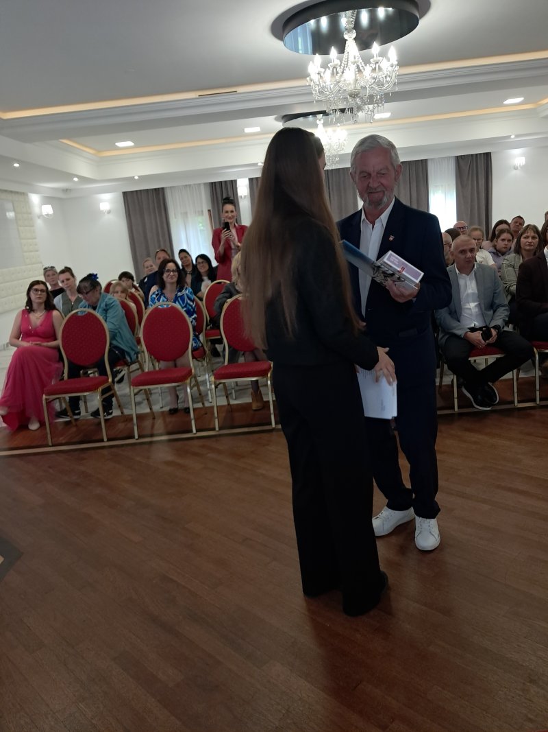 Zdjęcie przedstawia laureatkę konkursu w trakcie wręczenia nagrody  