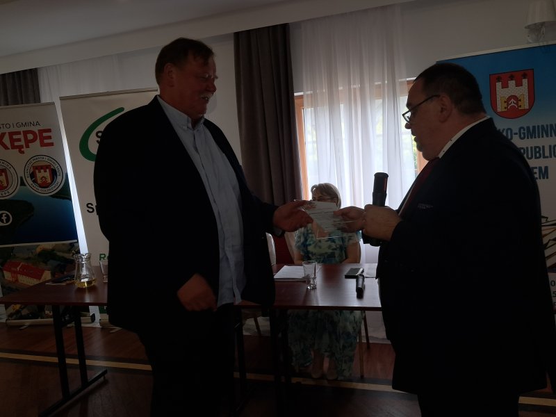 Zdjęcie przedstawia dyrektora biblioteki wręczającego podziękowanie członkowi Jury  