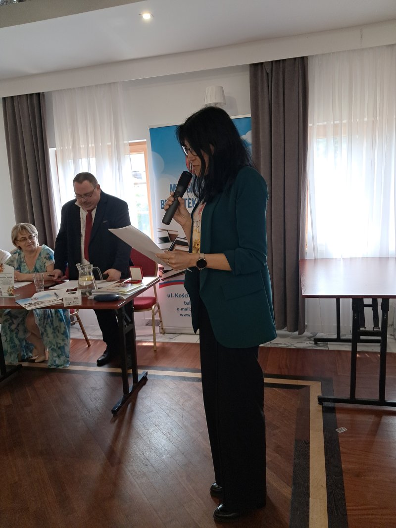 Zdjęcie przedstawia laureatkę konkursu czytającą nagrodzony wiersz  