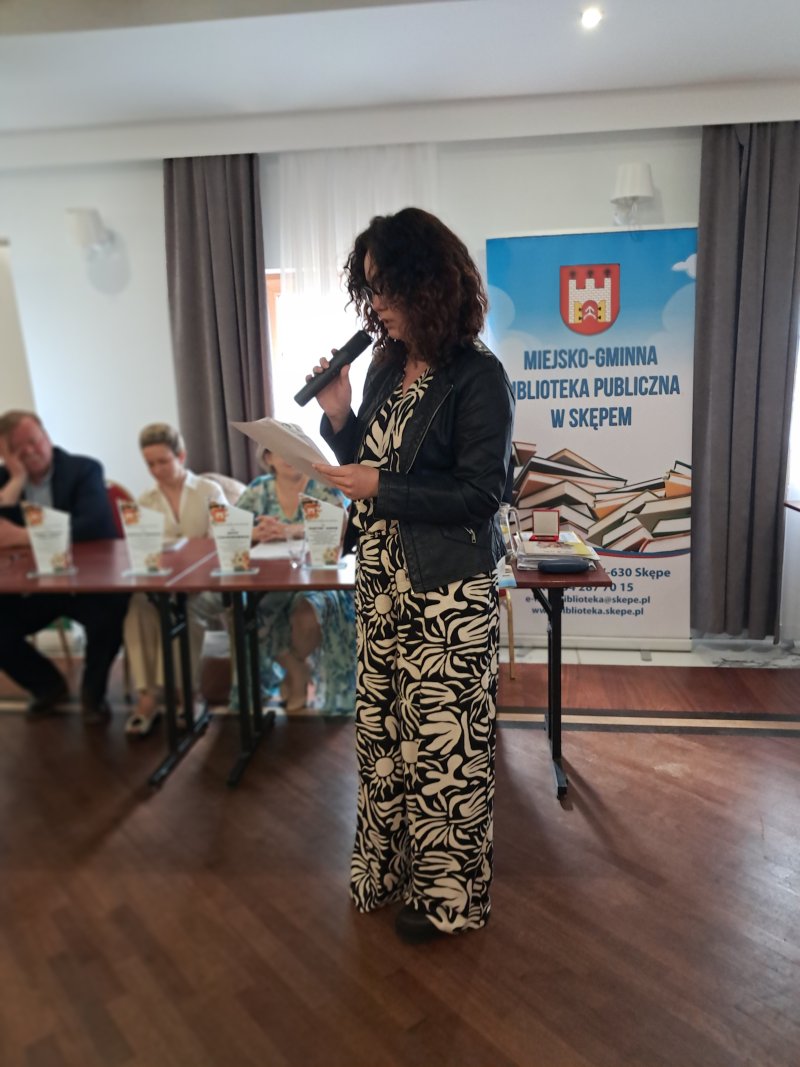 Zdjęcie przedstawia laureatkę konkursu czytającą nagrodzony wiersz  