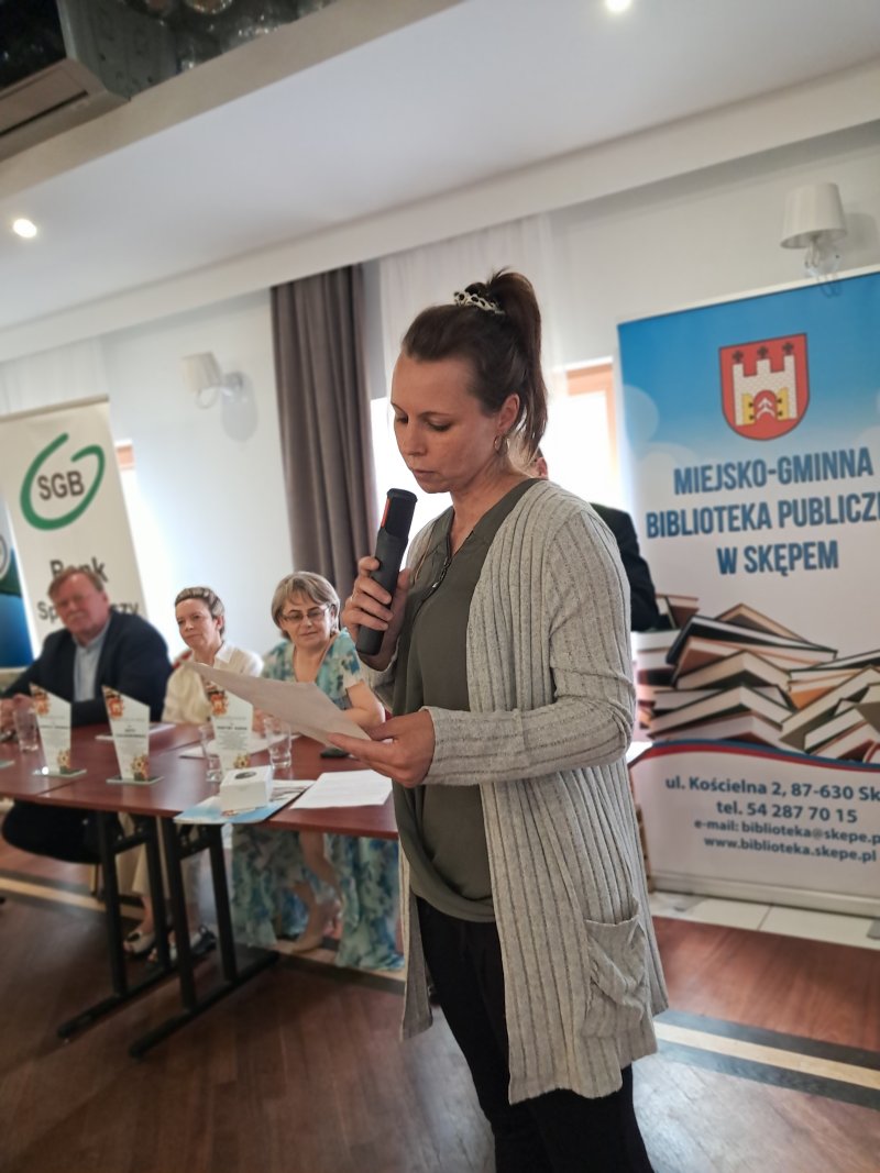 Zdjęcie przedstawia laureatkę konkursu czytającą nagrodzony wiersz  