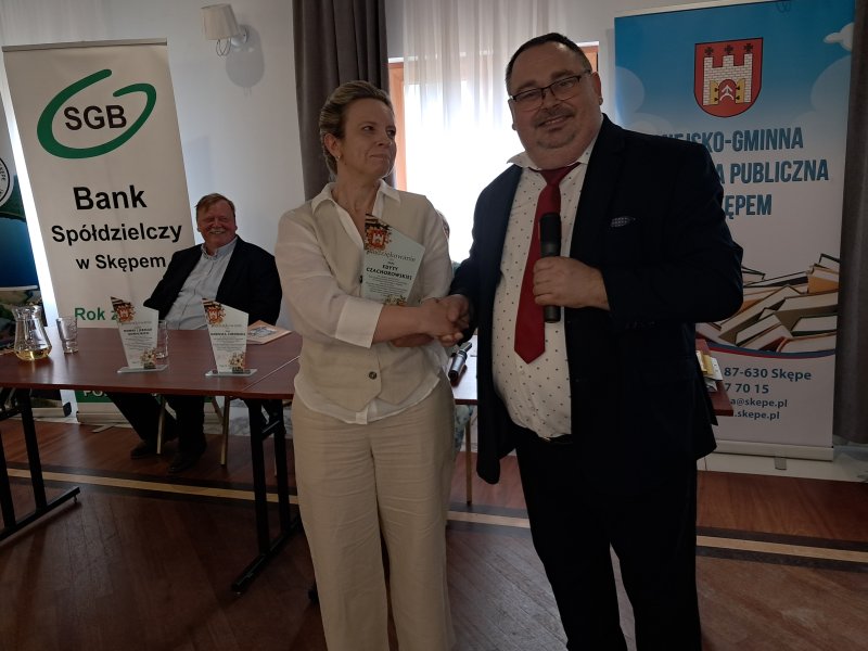 Zdjęcie przedstawia dyrektora biblioteki wręczającego podziękowanie członkowi Jury  