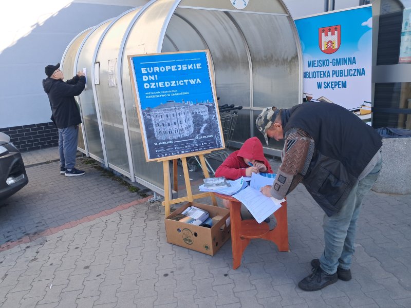 Widok ogólny na mieszkańców rozwiązujących quiz przed centrum handlowym   