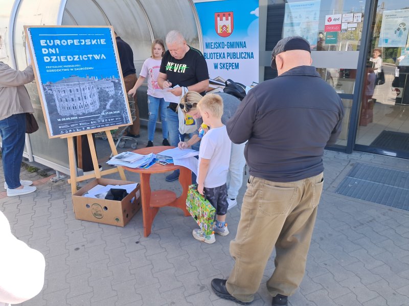 Widok ogólny na mieszkańców rozwiązujących quiz przed centrum handlowym   