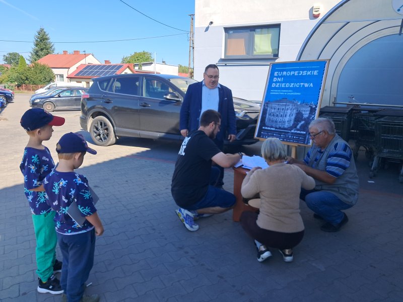 Widok ogólny na mieszkańców rozwiązujących quiz przed centrum handlowym   