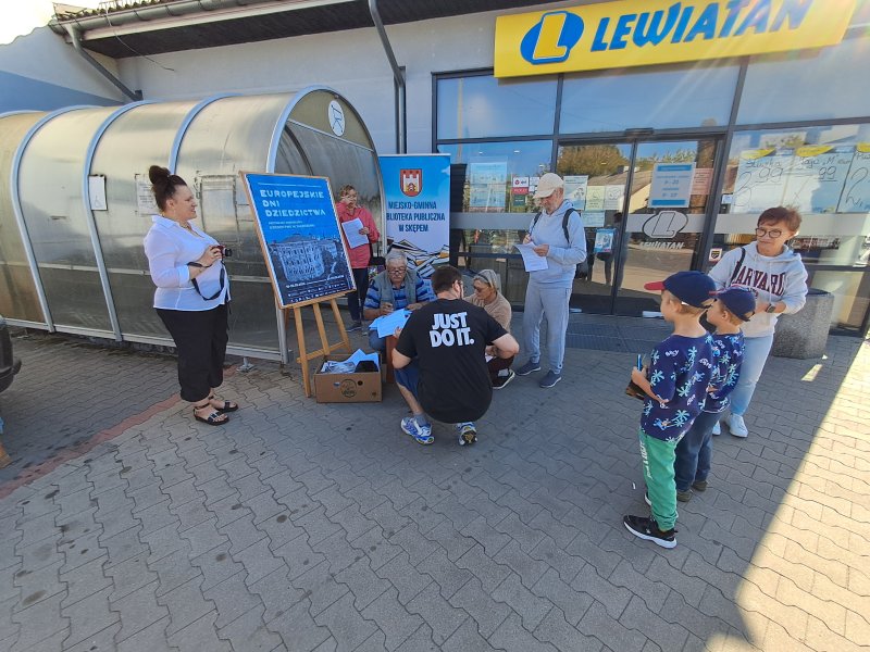 Widok ogólny na mieszkańców rozwiązujących quiz przed centrum handlowym   